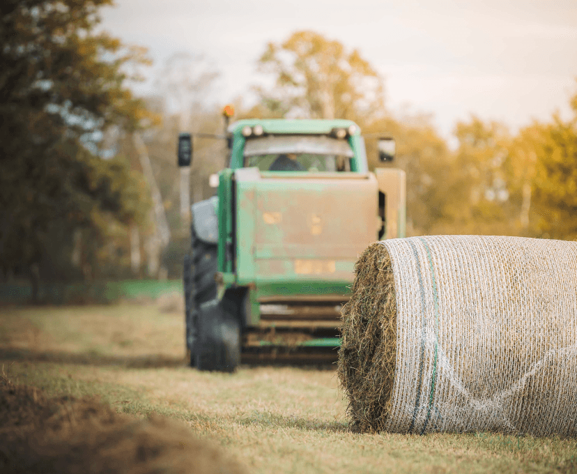 Tractor en hooibaal tijdens loonwerken in Zonhoven